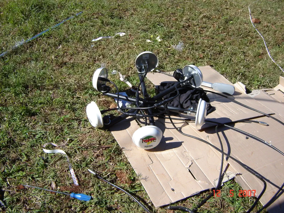 Rádios e antenas de 5 GHz da Tchêturbo montados sobre um papelão na grama, prontos para a instalação, em 2007